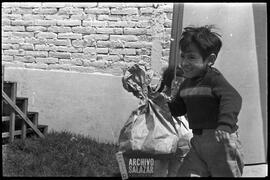 Canal 6 TV, Primera Maratón, 1961. Niño sonriendo con regalo en funda de papel.