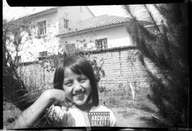 Niña no identificada sonrriendo a cámara.