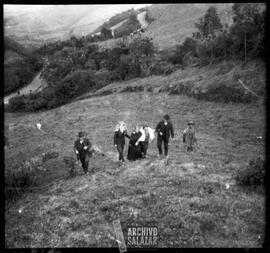 Josefina Paredes y Arturo Barrera con personajes no identificados caminando en el campo.