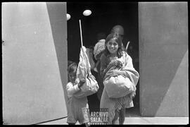 Canal 6 TV, Primera Maratón, 1961. En primer término, niña y niño saliendo de instalaciones del canal con regalo en funda de papel. Atrás, un policía.